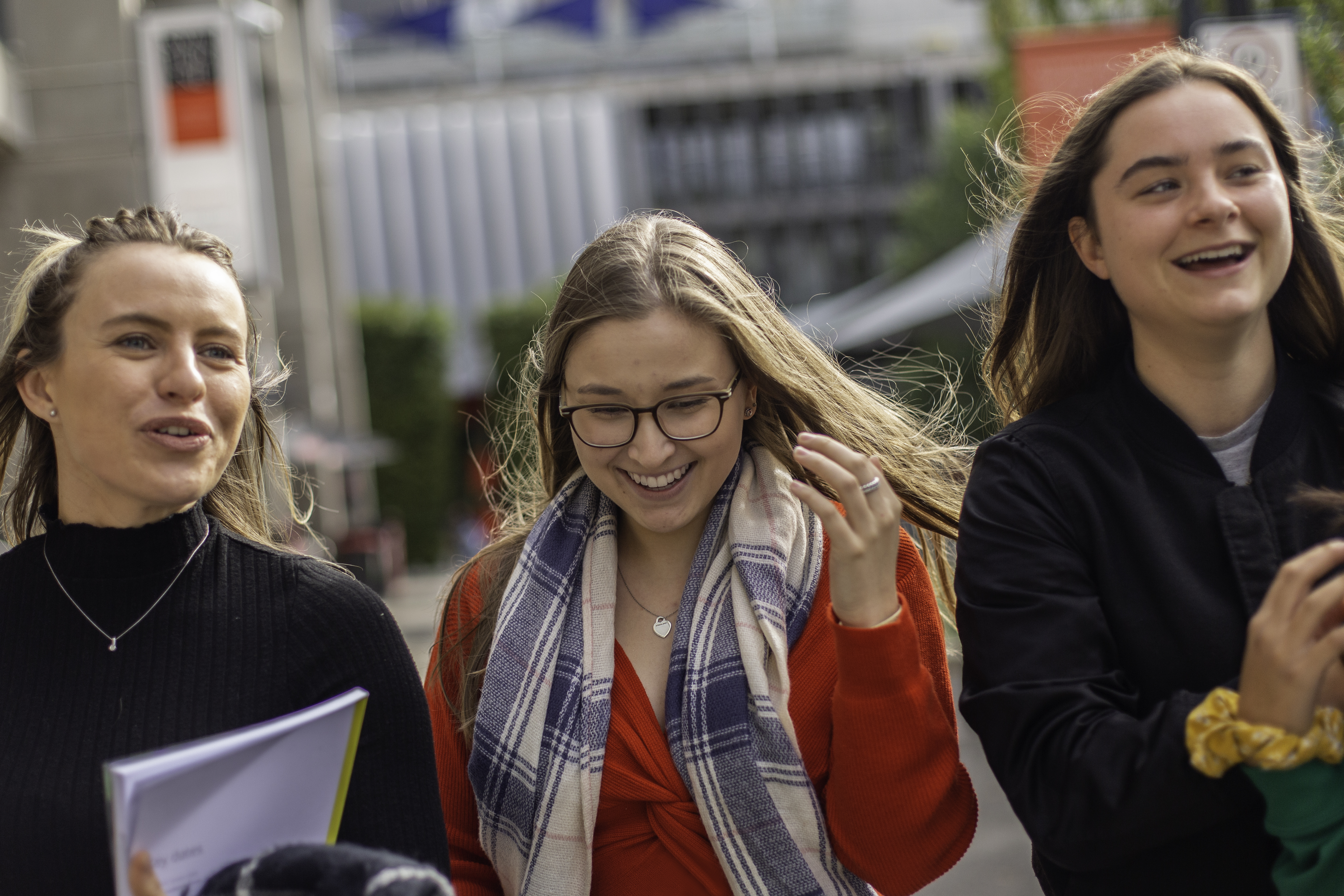 Three female students chatting as they walk around the Hawthorn campus