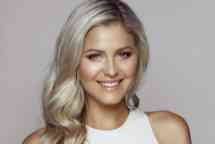 Victoria Curtis smiles to camera with plain grey background