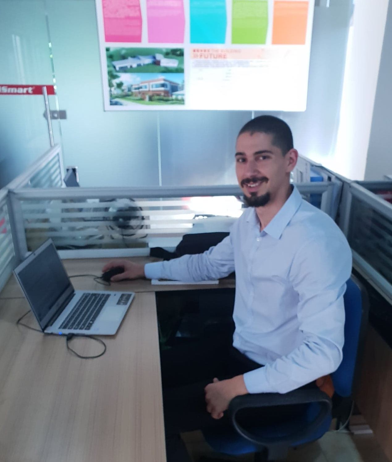Man sitting at a desk smiling at the camera