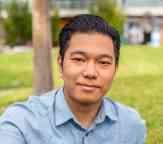 Closeup of Noah Htin Lin Htet smiling to camera with the Swinburne quad blurred in the background