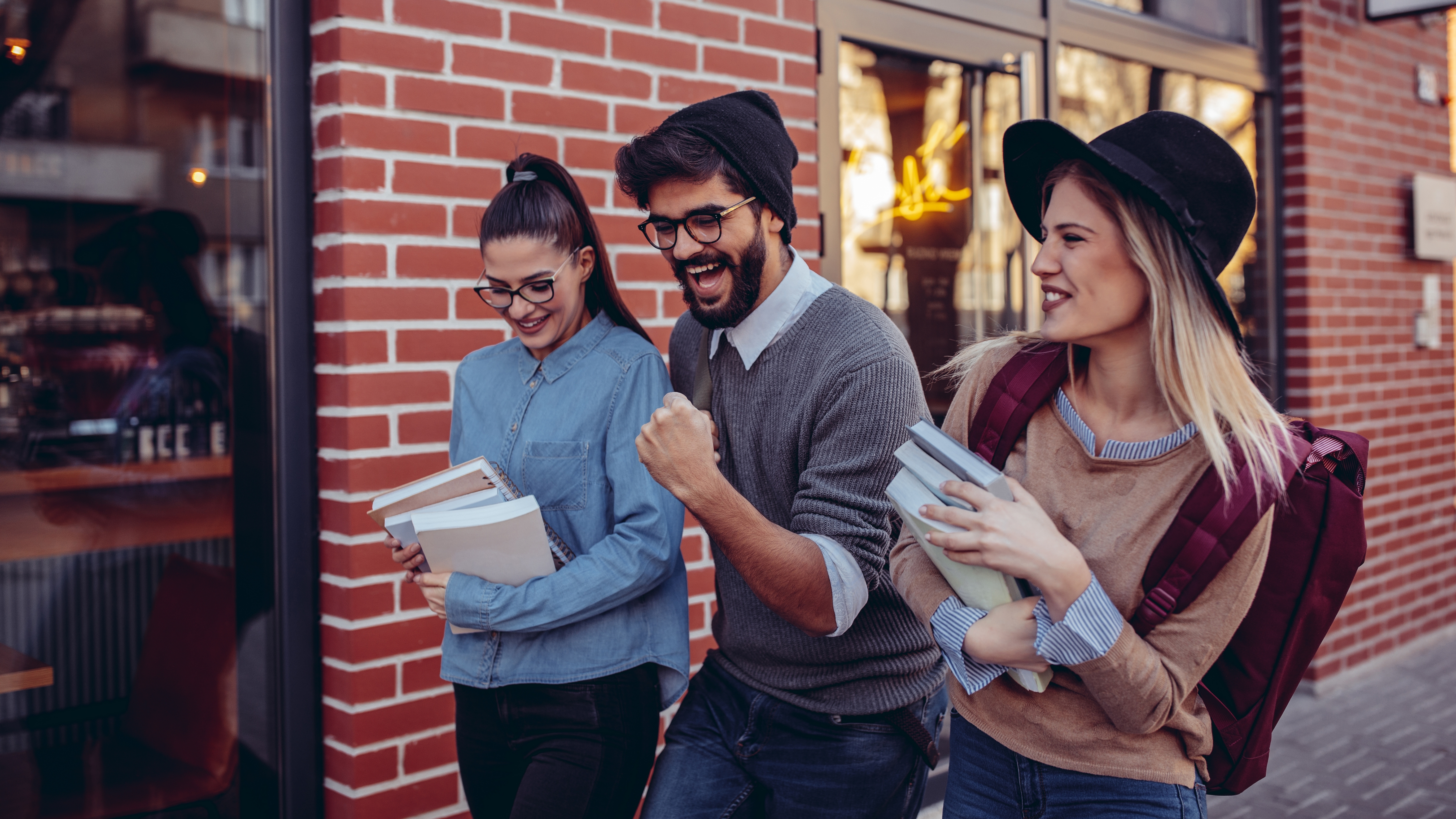 Happy smiling students laughing whilst walking outdoors.