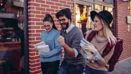Happy smiling students laughing whilst walking outdoors.