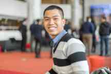 Male business student smiling to camera wearing a striped jumper