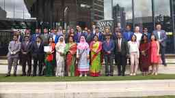A large group of people standing outside a university building in front of the Swinburne logo.