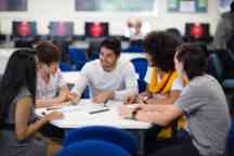 Students studying at a desk working on a group assignment 