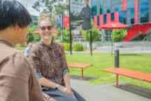 Students sitting in the sun outside the George building talking