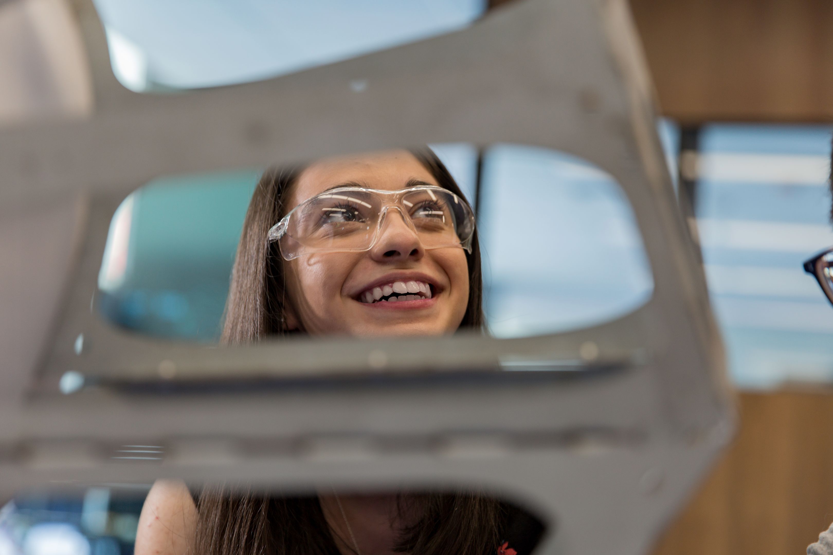 Young woman wearing safety glasses smiling 