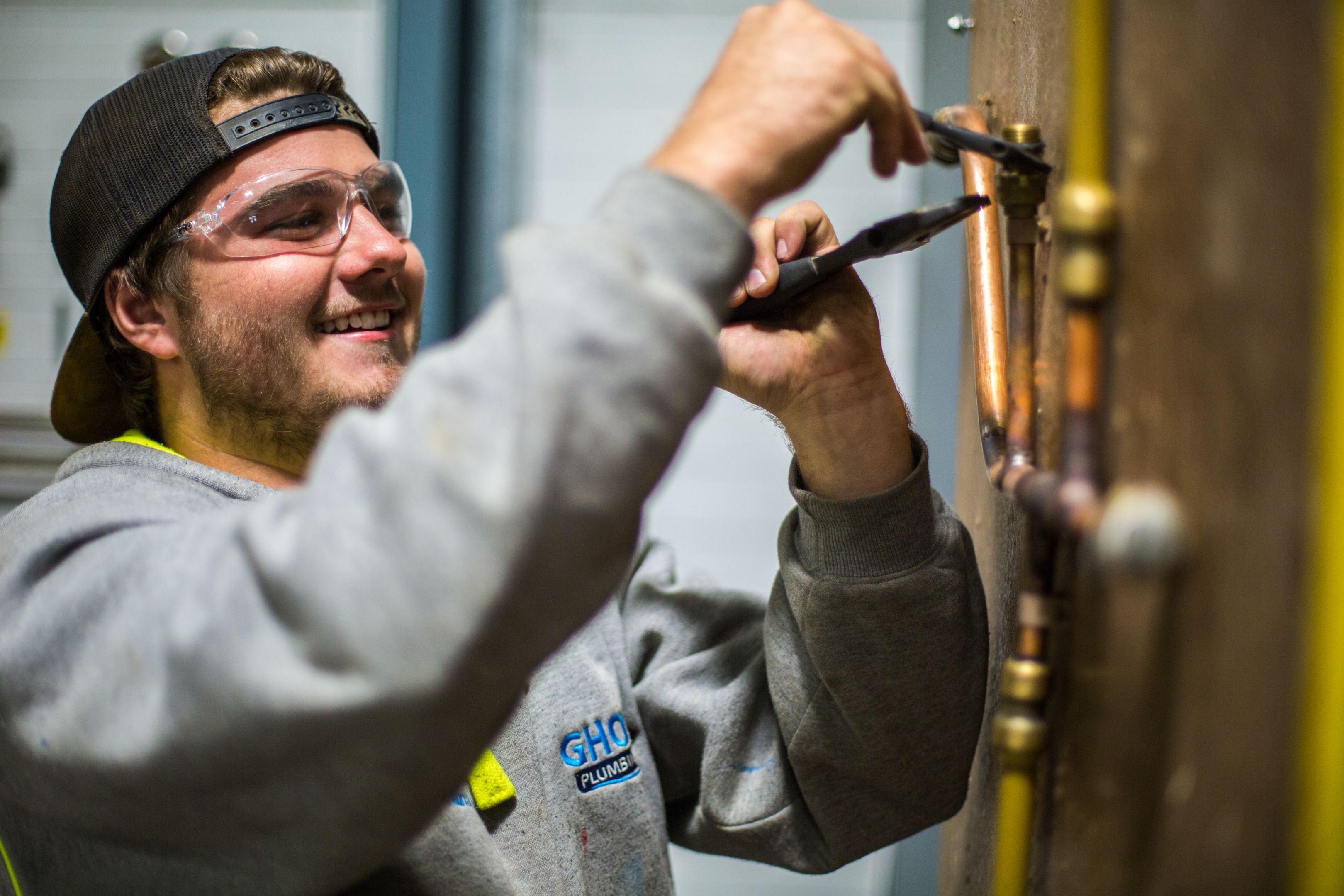 Apprentice plumber working on a pipe chain at the Croydon campus