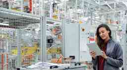 Female supervisor using tablet PC in car factory