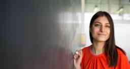 Pretty, young college student writing on the chalkboard/blackboard